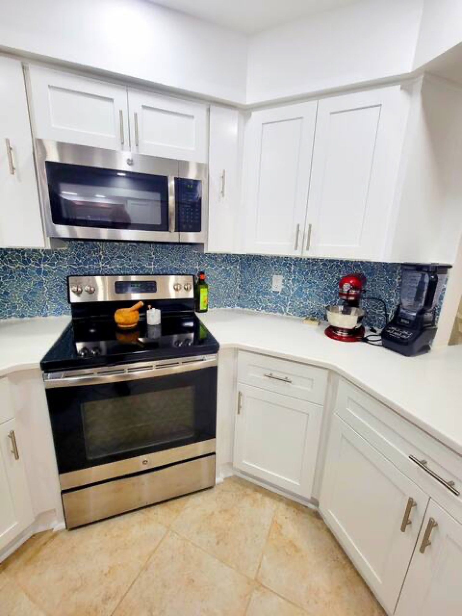Kitchen stove with blue mosaic backsplash and KitchenAid mixer